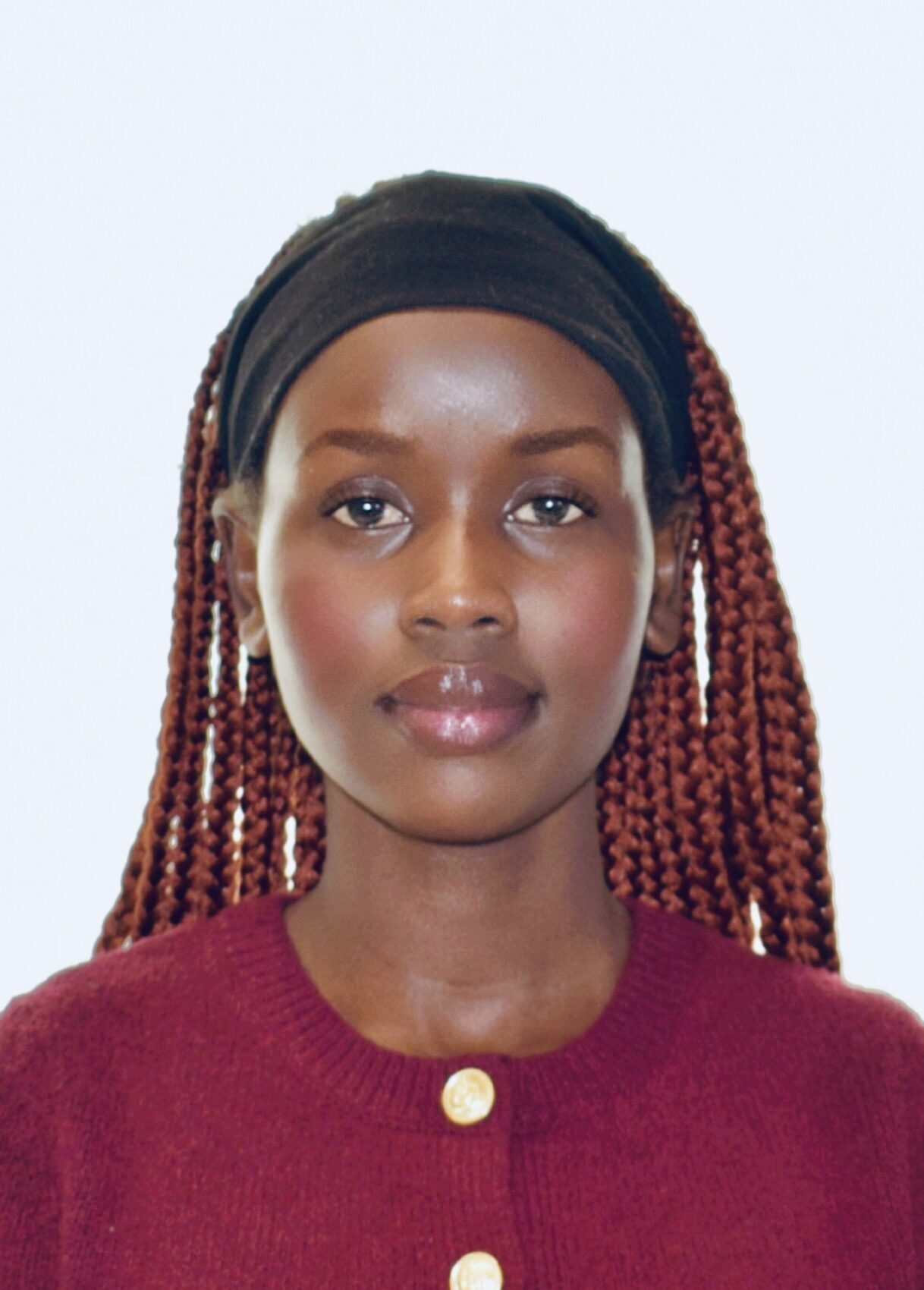 A person with red hair wearing a black headband and red sweater.